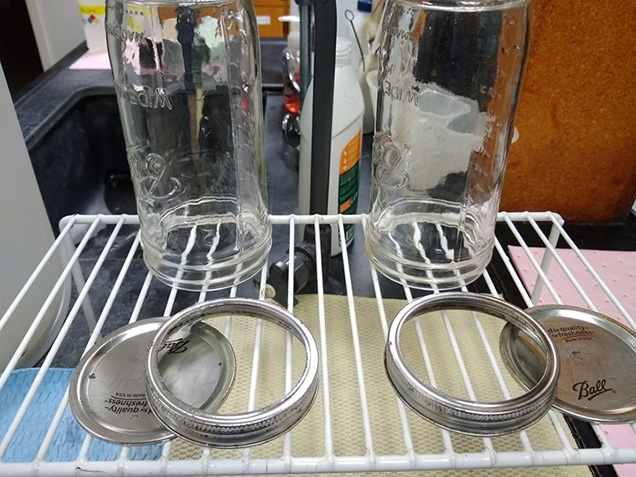 two glass jars drying on rack