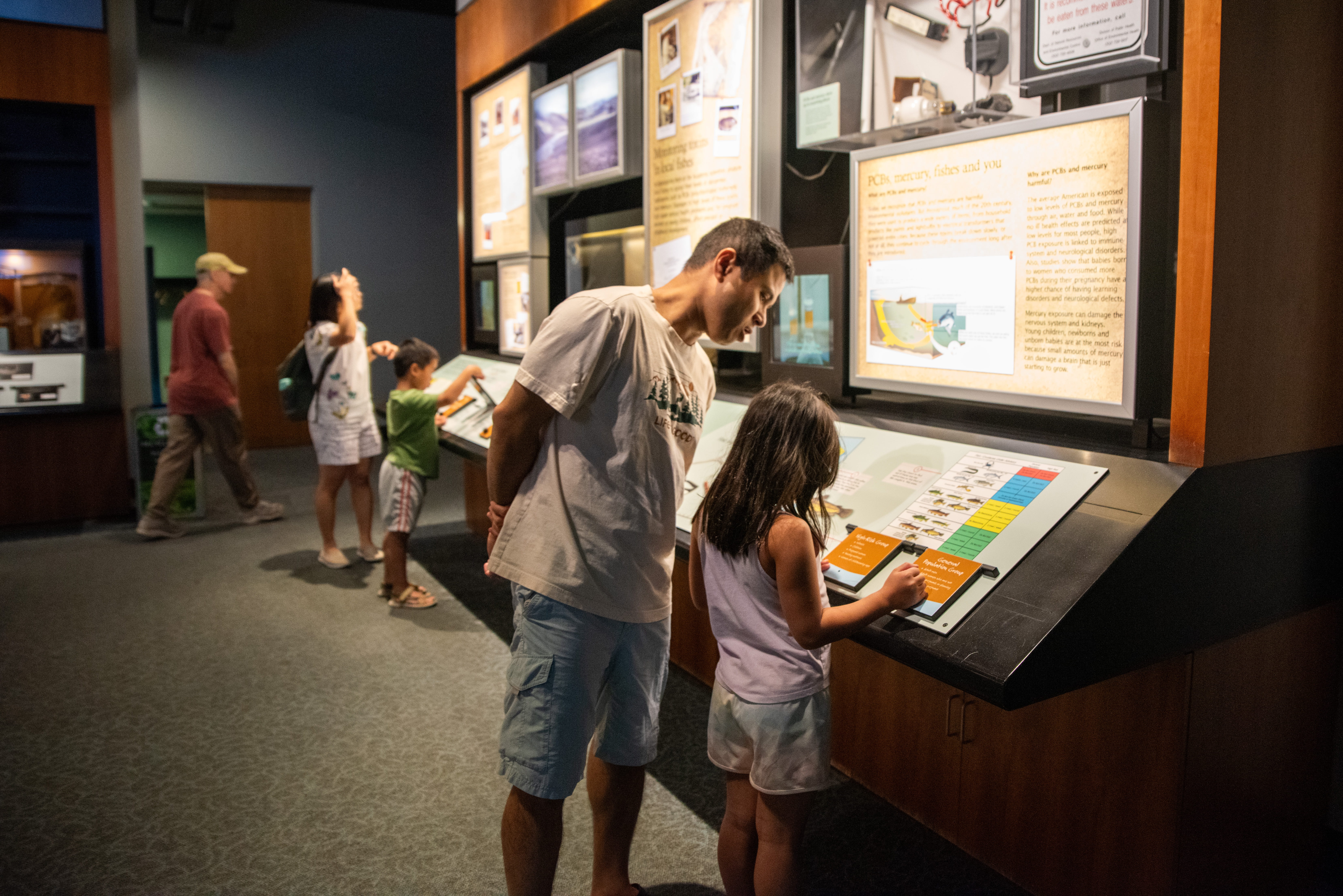 Several people are looking at a wall with scientific information.