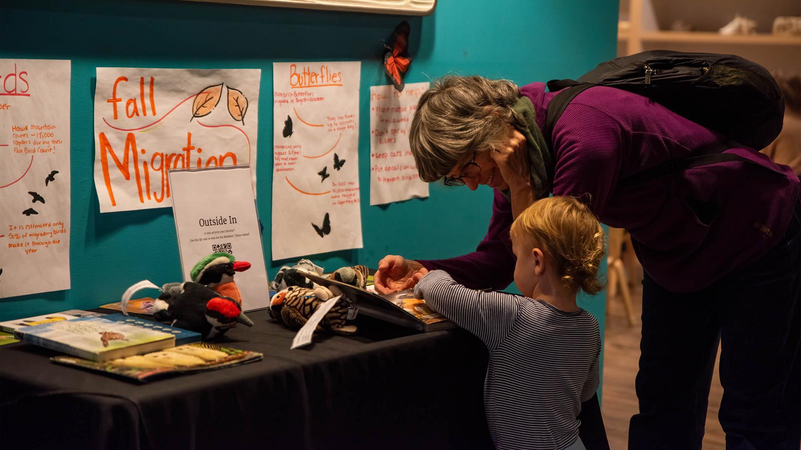 A parent and a child reading an activity in Outside-In.