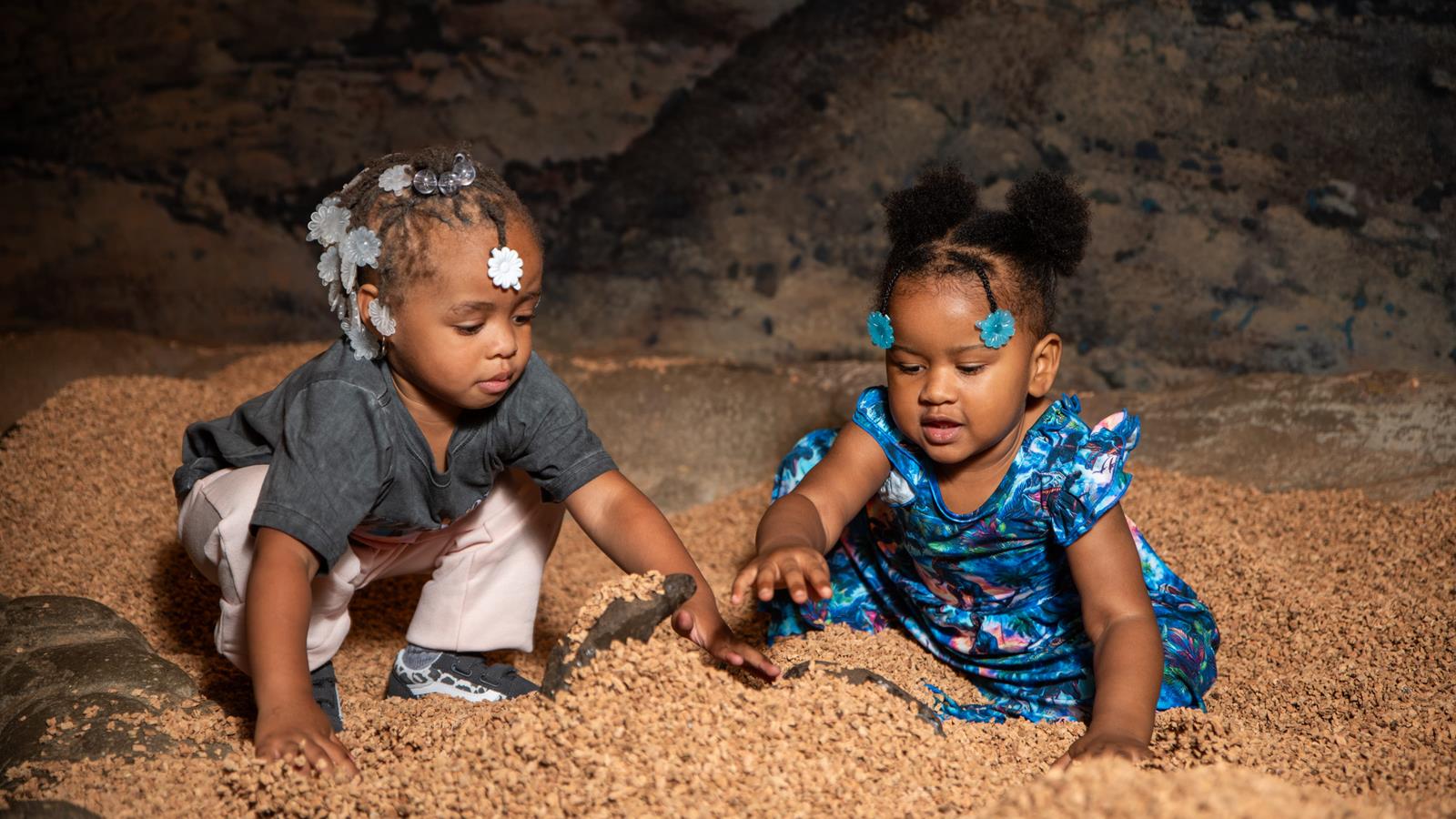 Two little children looking for fossils in the big dig.