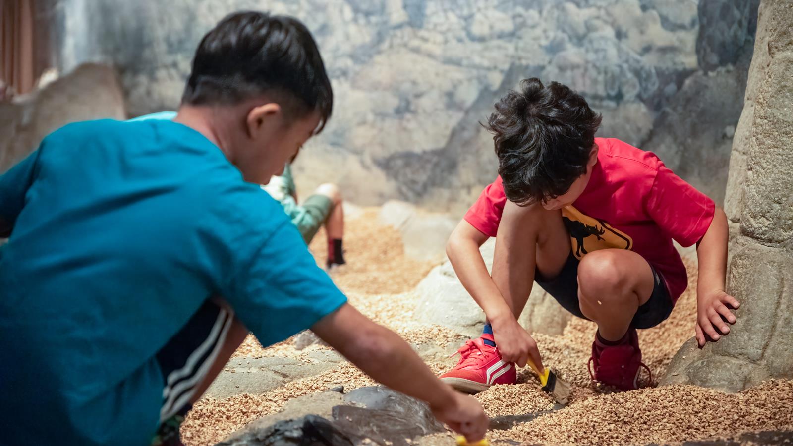 Two children looking for fossils in the big dig.