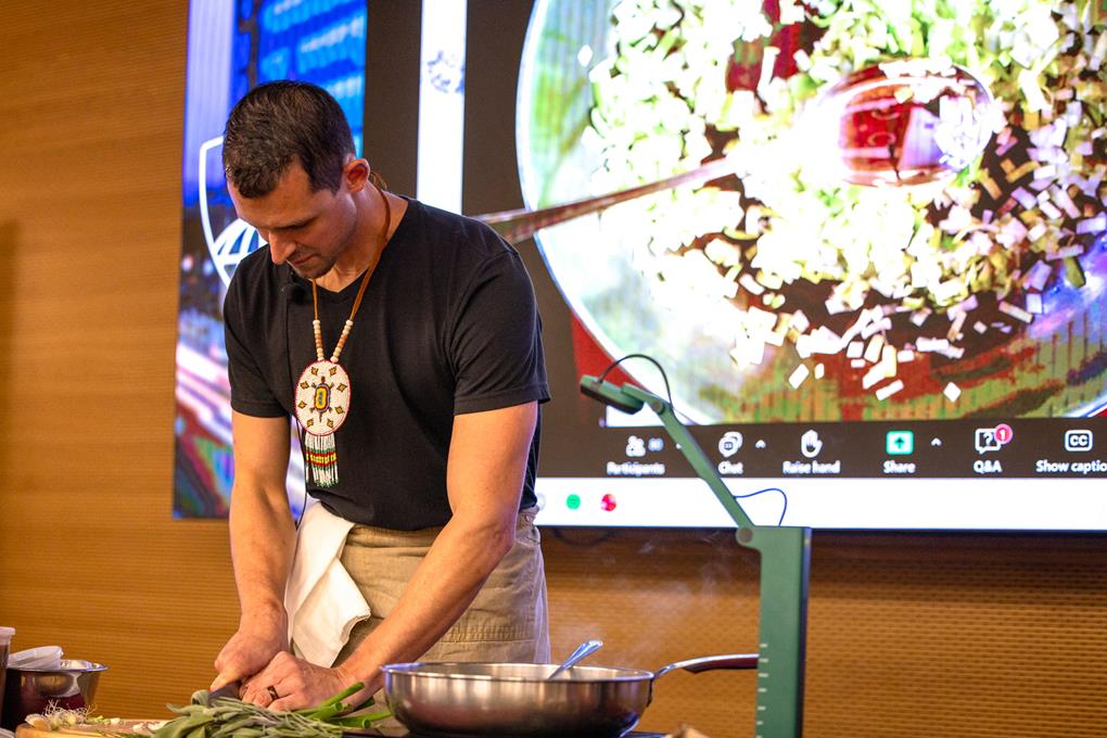 A chef cutting vegetables on stage.