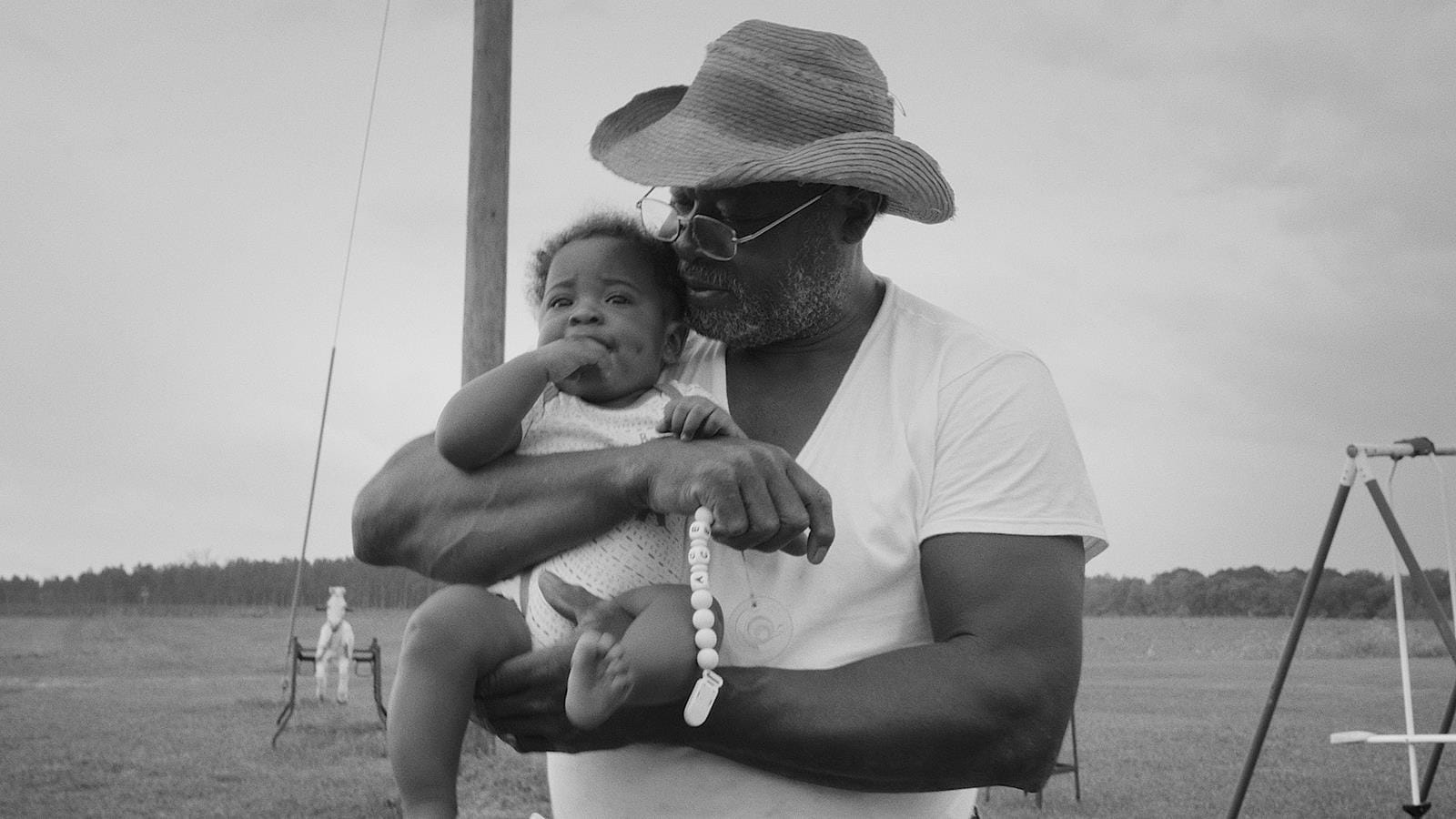 An african american man holding a child onboard of a boat.