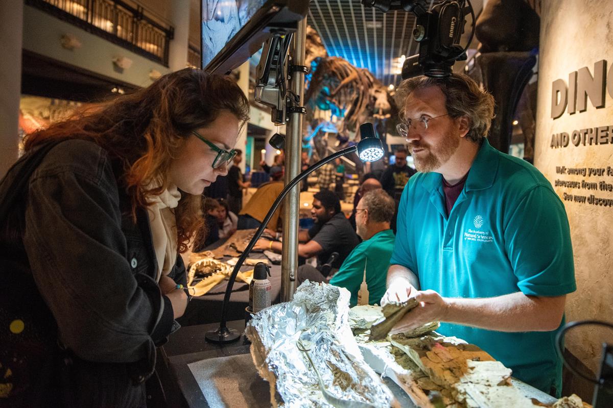 An Academy educator showing off dinosaur fossils.