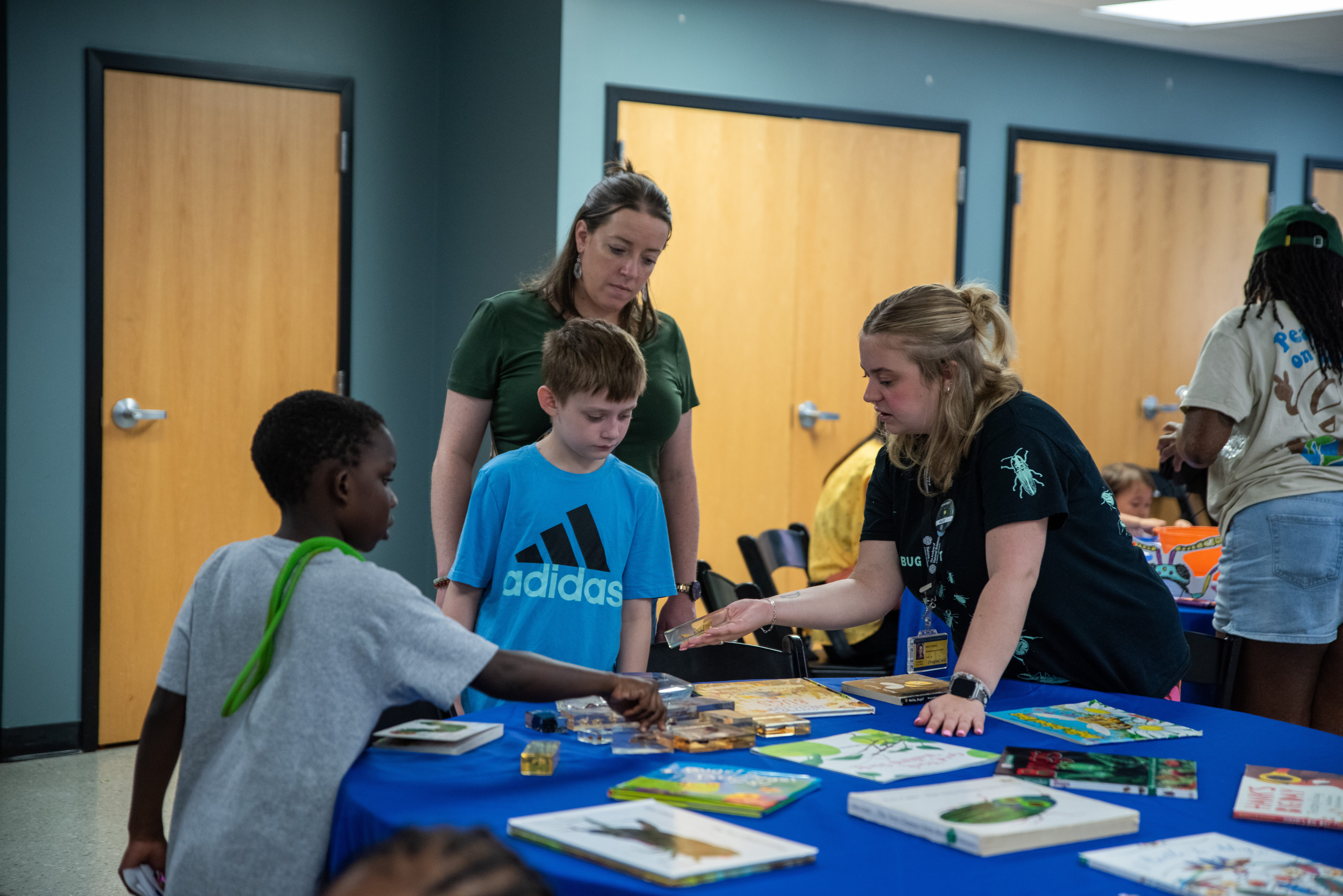 an academy educator shows a specimen to two children.