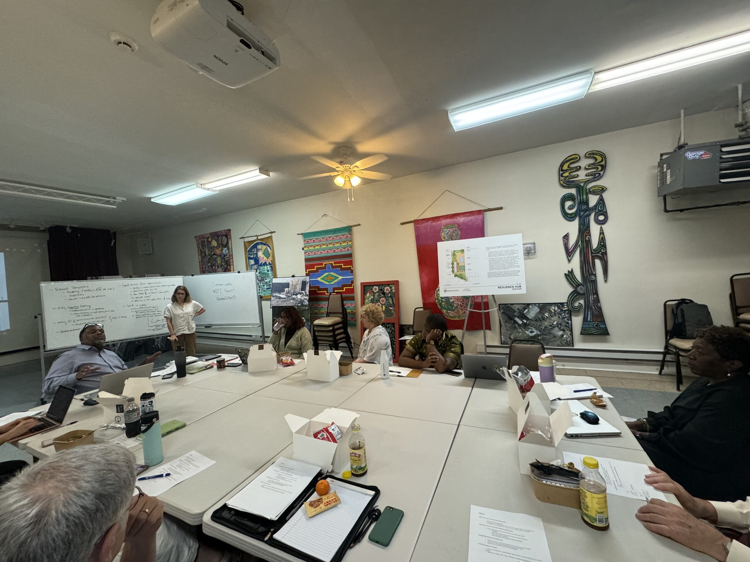 A group of people sitting around a table meeting and having lunch.