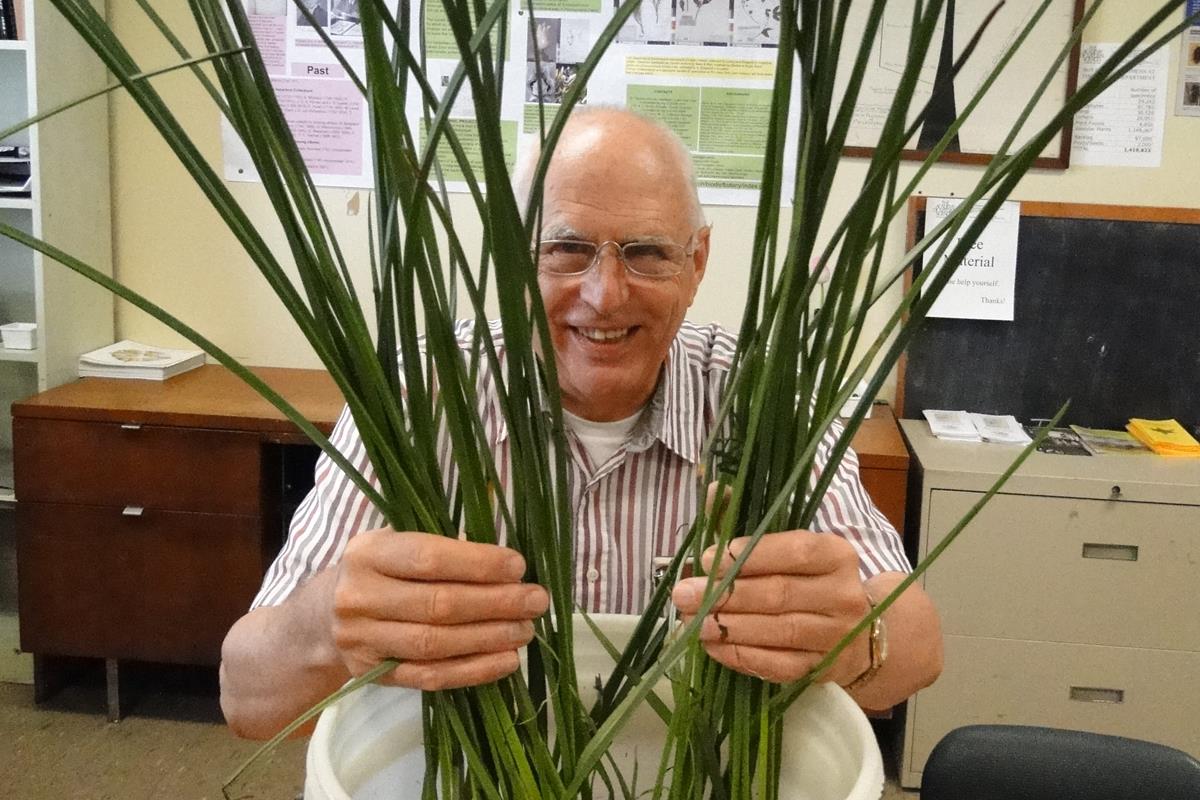 Staff scientist Ernie Schuyler hiding behind a plant.