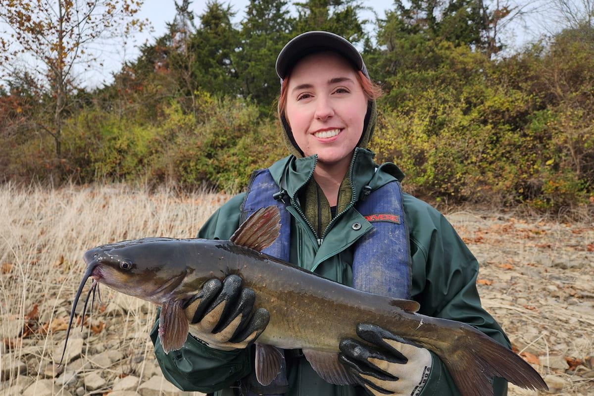 A photo of Fisheries Scientist, Kendal Morgan, holding a catfish.