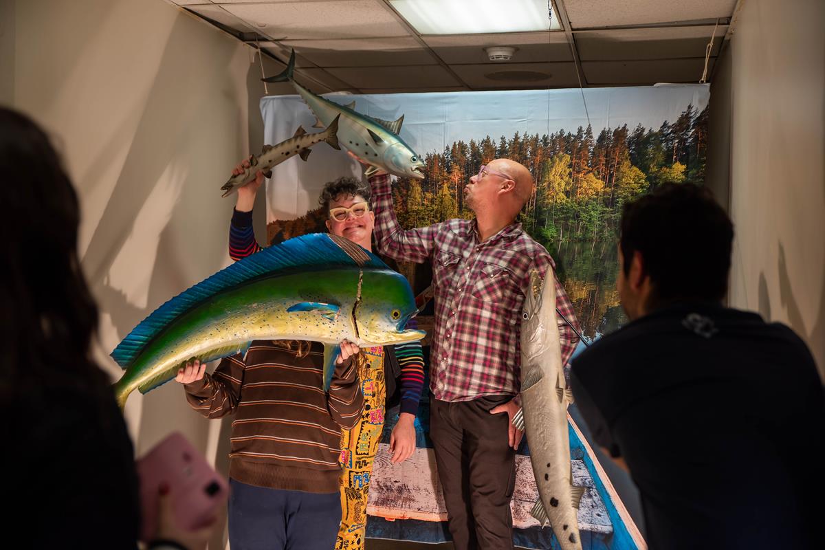 A family of members posing with some dead fish.