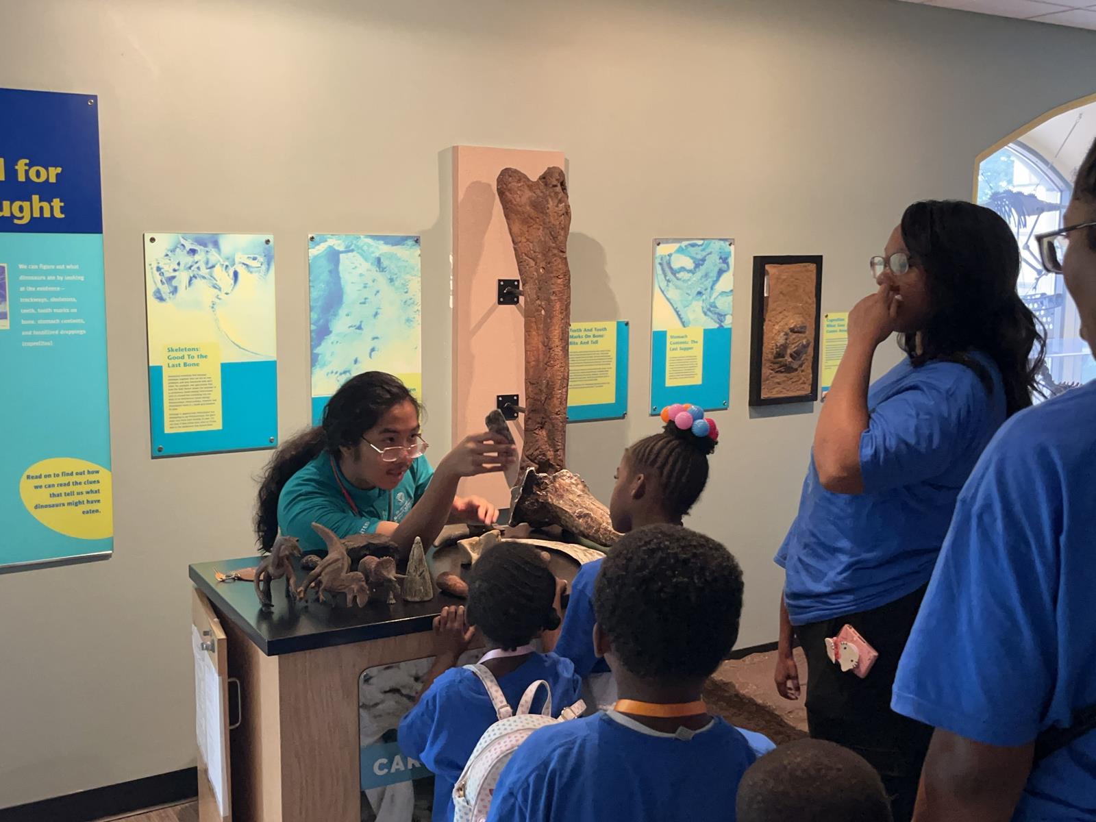A volunteer showing off fossils to a school group with young children.