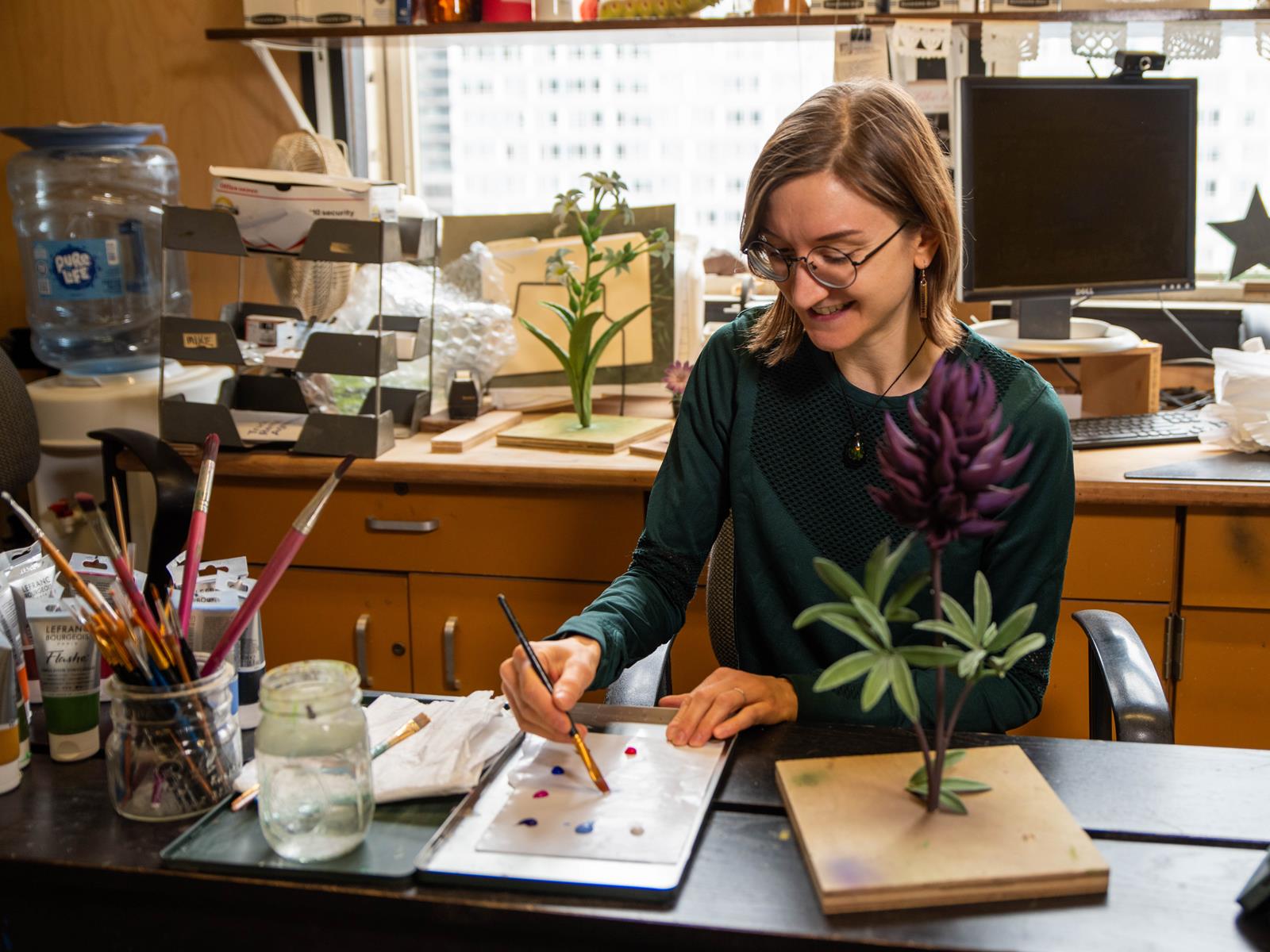 The artist, Lindsay Lindhult, mixes paint.