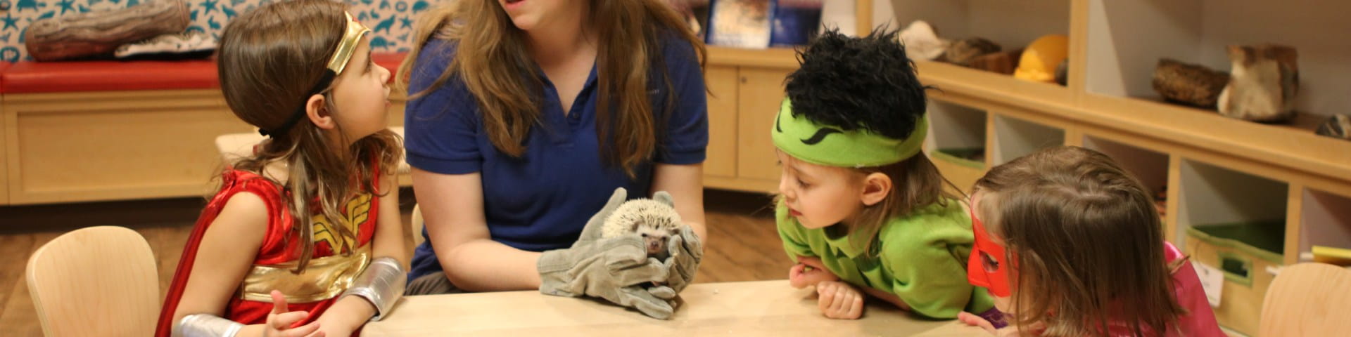 kids in costume with educator and hedgehog