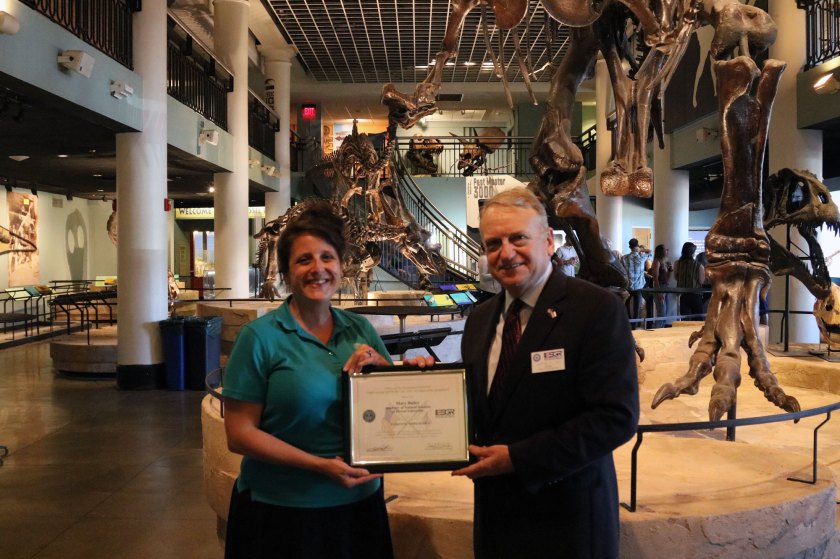 Academy employee Mary Bailey receives award from man in suit