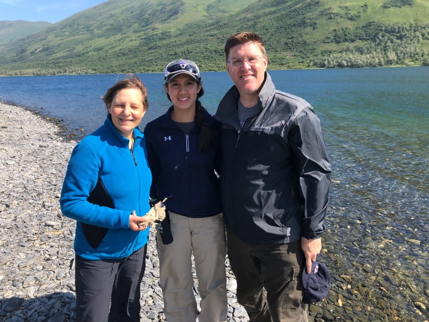 Three scientists stand beside Karluk Lake on Kodiak Island, Alaska
