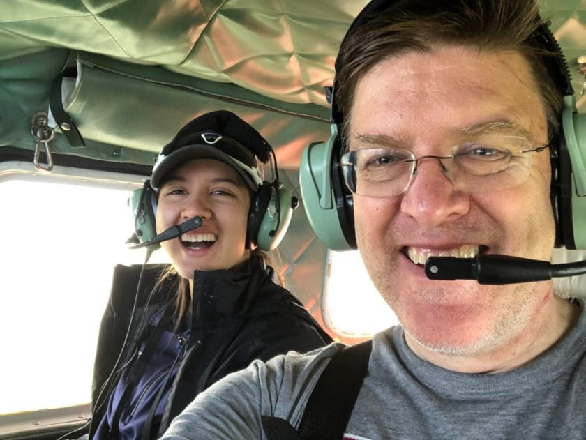 Two scientists ride in plane with earmuffs and mouth pieces
