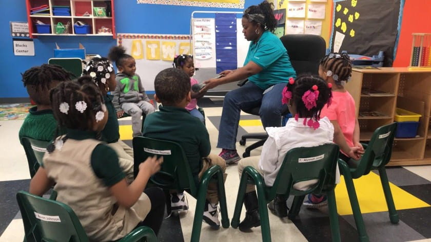 Woman guides students in discussion in a classroom