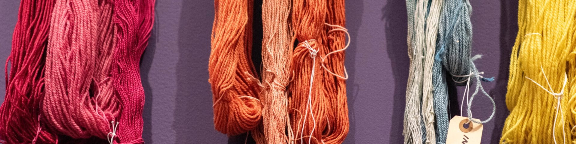 colored yarn hanging on wall