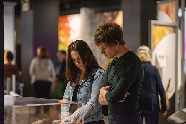 Two adults looking at specimens in the SKIN exhibit.