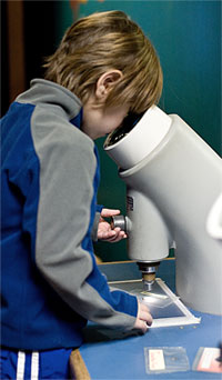 photo of boy and microscope in Outside In