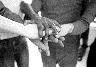 A close up image of kids putting their hands on top of one another.