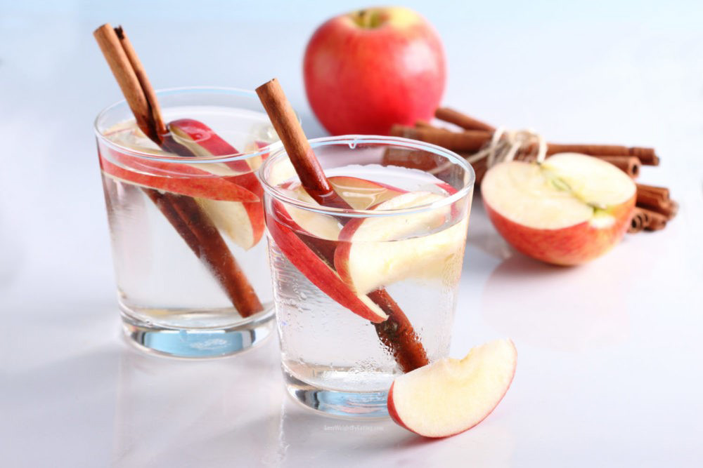 drink in clear glass with apple and cinnamon stick