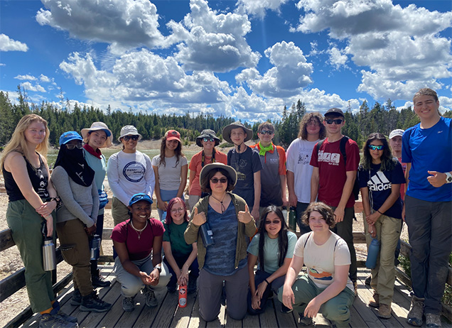 group of high school students at yellowstone with blue skies and white clouds