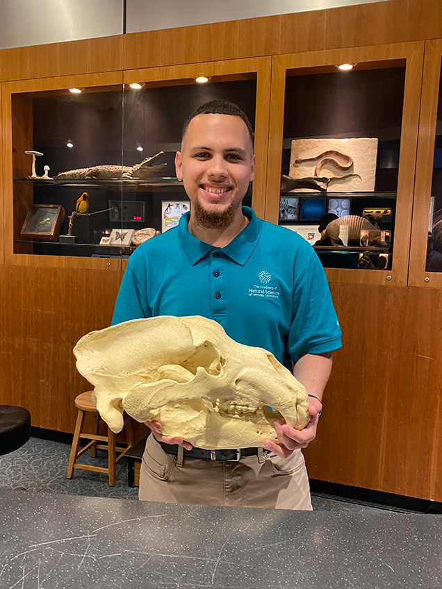 nathan nazario smiling and holding an animal skull 