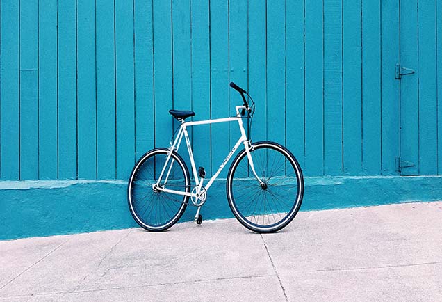 A bicycle against a light blue wall.