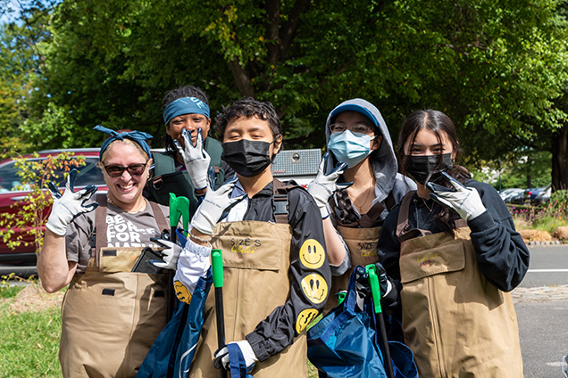 A group of people posing for a camera during a clean-up.