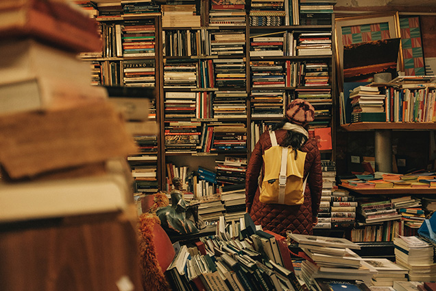 A person looking at books in a thrift store.