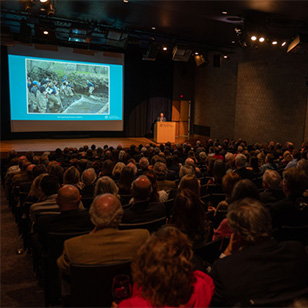 A group of visitors in the auditorium during a presentation.