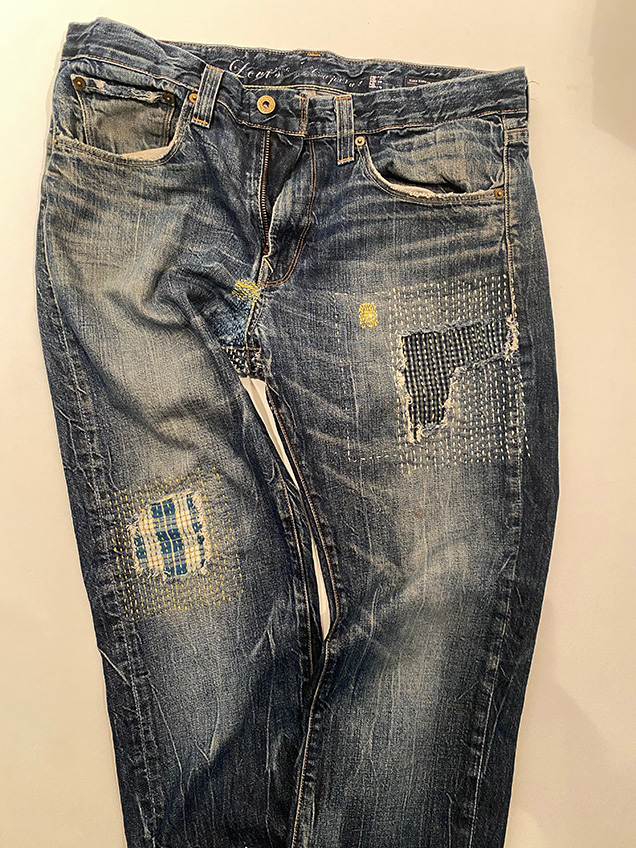 a pair of blue jeans with worn sections indicating wear